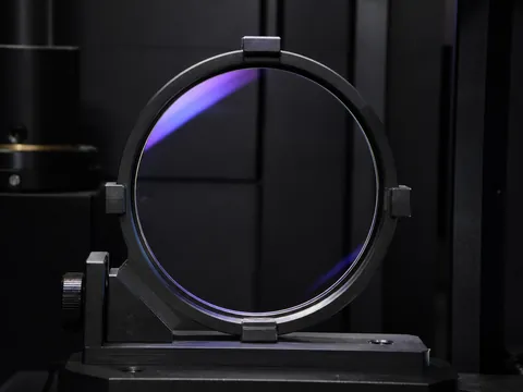 UV420 blue-filter optical lens positioned for transmission and coating inspection